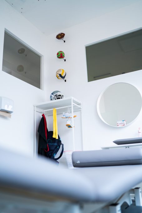 Blick in einen hellen Raum mit Wanddekorationen und einem runden Spiegel.