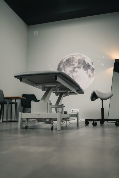 Behandlungsstuhl in einem modernen Raum mit einem großen Globus im Hintergrund.